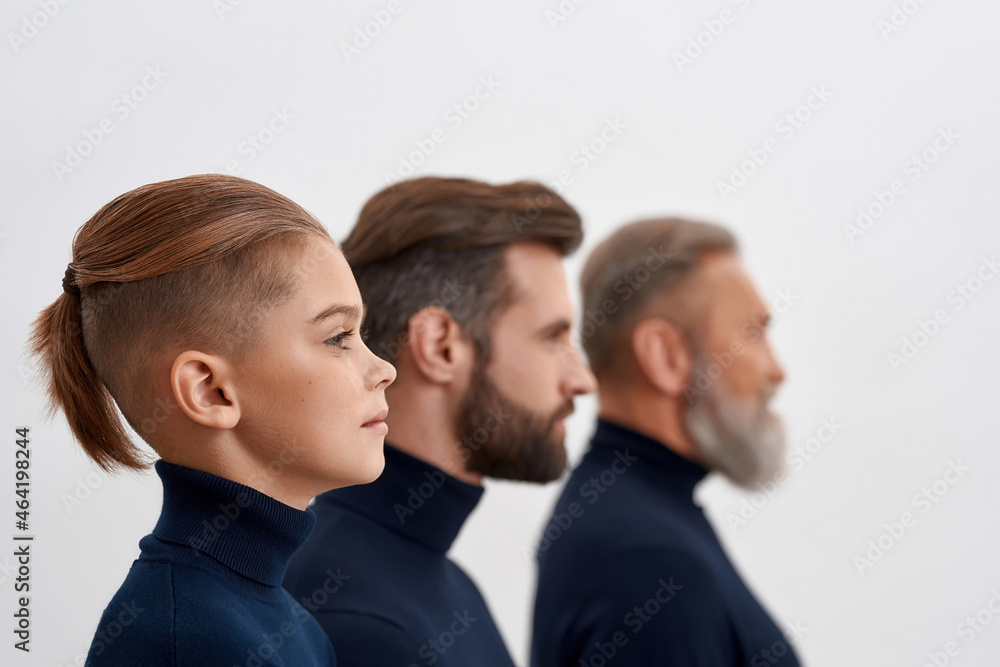 Three generations of Caucasian men stand in row Three generations of Caucasian men stand in row