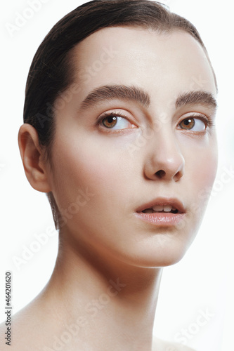 Closeup portrait of beautiful girl with clean shiny healthy skin and nude makeup. Natural skincare beauty.