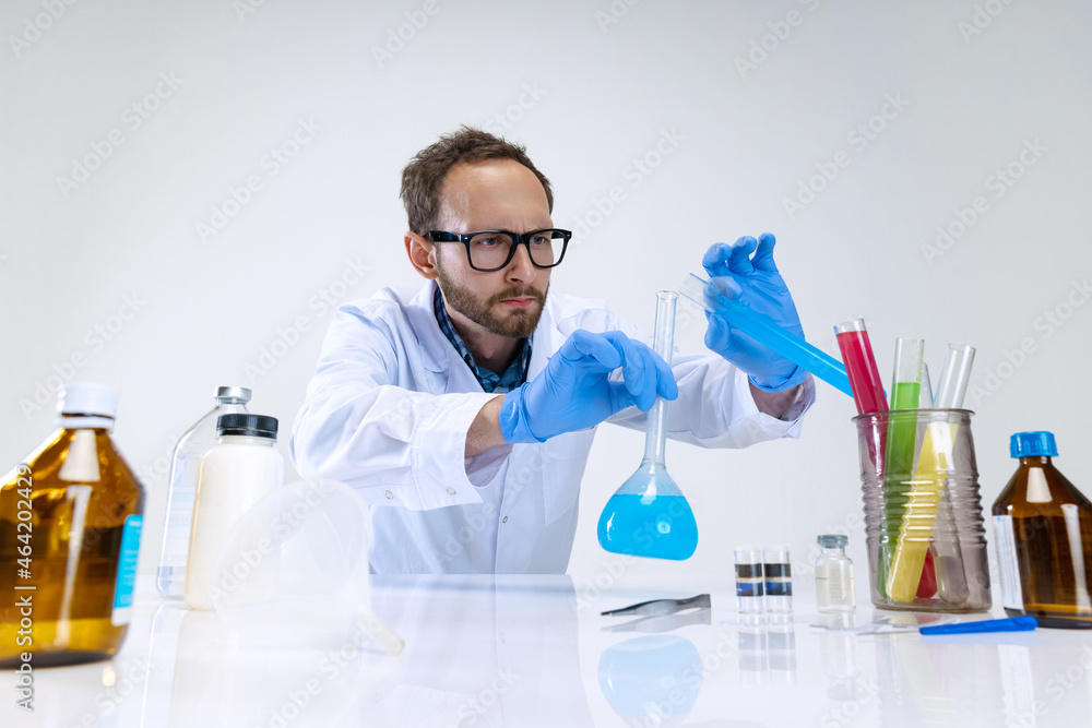 Portrait of young scientist, chemist or doctor conducts chemical research at pharmaceutical lab. Concept of chemistry, medicine. Portrait of young scientist, chemist or doctor conducts chemical research at pharmaceutical lab. Concept of chemistry, medicine.