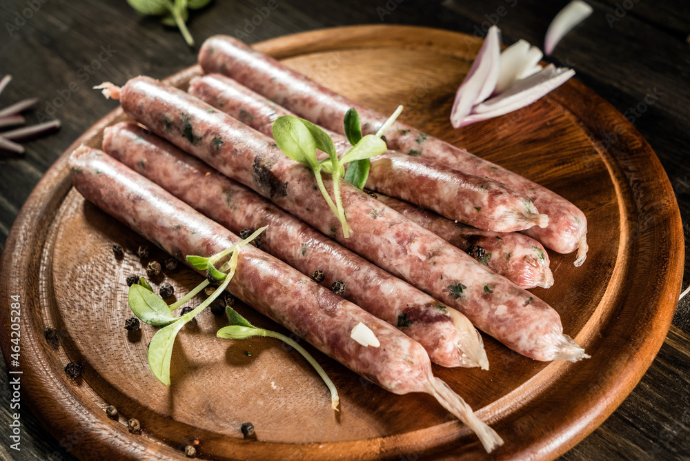 raw sausages on the wooden tray