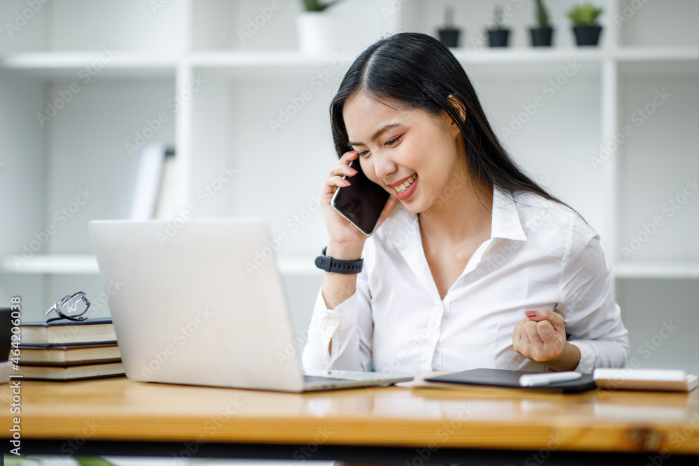 Portrait of Asian young female Businesswoman working on laptop computer doing finances,accounting analysis,report,data and pointing graph at the office. Portrait of Asian young female Businesswoman working on laptop computer doing finances,accounting analysis,report,data and pointing graph at the office.