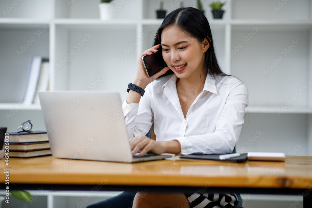 Portrait of Asian young female Businesswoman working on laptop computer doing finances,accounting analysis,report,data and pointing graph at the office. Portrait of Asian young female Businesswoman working on laptop computer doing finances,accounting analysis,report,data and pointing graph at the office.