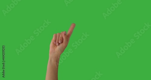 Woman waving her index finger in denial over green background