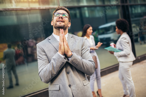 Business man praying with hands together asking for forgiveness confident.