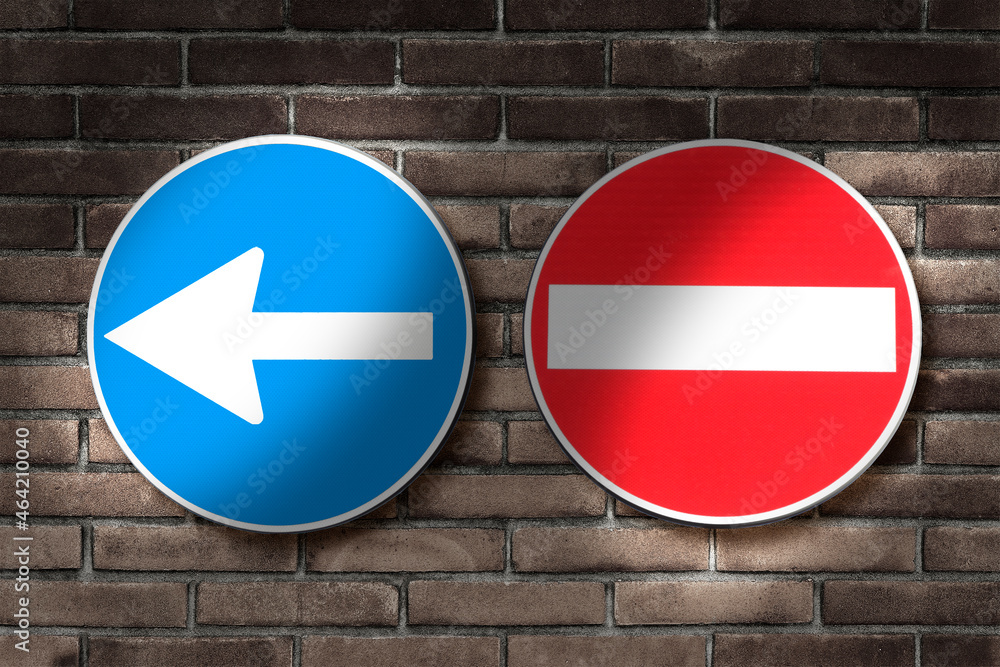 Directional arrow road sign and no entry road sign against a brick wall - concept image Directional arrow road sign and no entry road sign against a brick wall - concept image