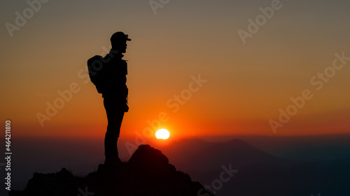 Mountaineer on the top of the mountain watching the fantastic sunset