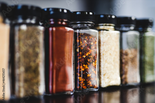 Fototapeta Naklejka Na Ścianę i Meble -  spices seeds and seasonings in mathing spice jars on tidy pantry shelf, simple vegan ingredients and flavoring your dishes