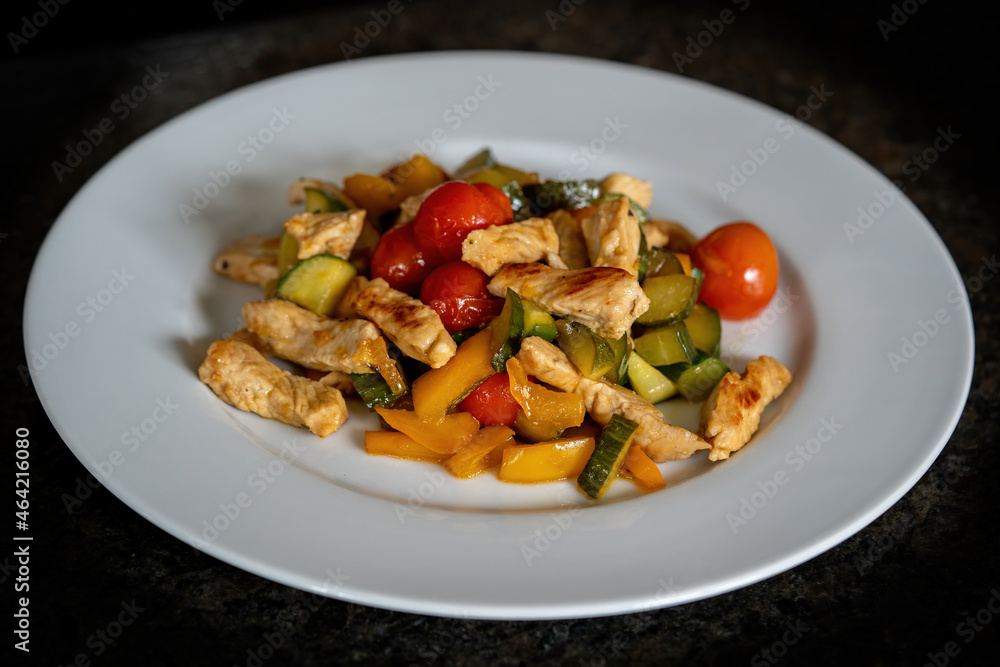 ready to eat - roasted chopped turkey with cherry tomatoes, cucumber, yellow paprika on a white plate