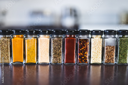 Fototapeta Naklejka Na Ścianę i Meble -  spices seeds and seasonings in mathing spice jars on tidy pantry shelf, simple vegan ingredients and flavoring your dishes