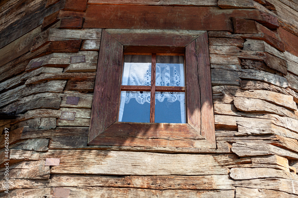 Rustic house made by wooden beams . Window and wooden wall