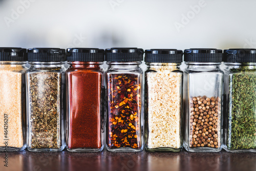 Fototapeta Naklejka Na Ścianę i Meble -  spices seeds and seasonings in mathing spice jars on tidy pantry shelf, simple vegan ingredients and flavoring your dishes