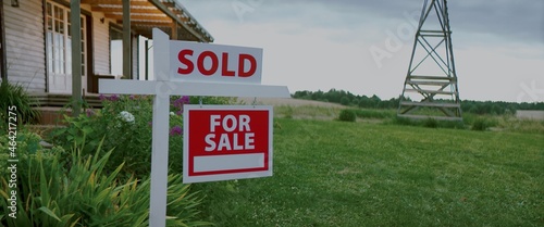 Obraz na plátne For sale sign standing on a lawn in front of an American style house