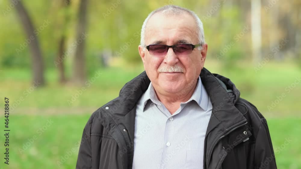 Senior man with a mustache in the park. portrait of a gray-haired man in a shirt and black jacket. Senior man with a mustache in the park. portrait of a gray-haired man in a shirt and black jacket.