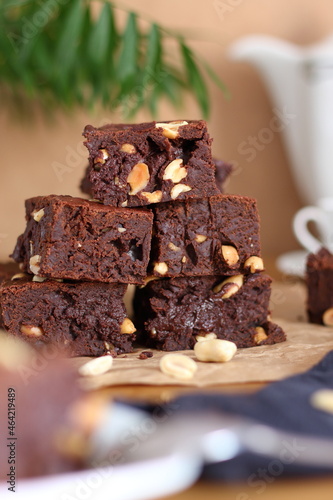 A stack of chocolate brownies with peanuts on snack table. Homemade bakery and dessert.