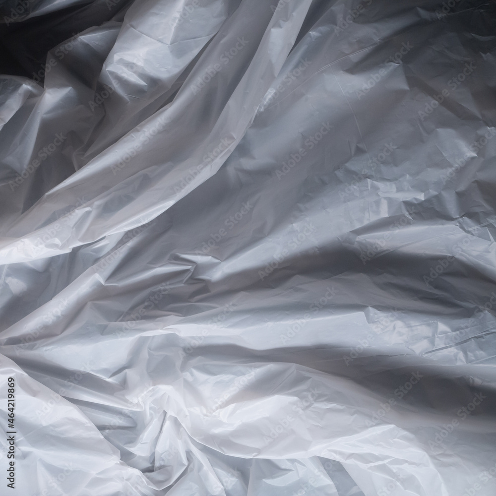 Fototapeta premium Reflecting light and shadow on creases and folds in scrunched white fabric or plastic sheet