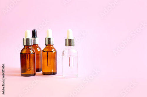 bottles of hyaluronic acid on a pink background taking care of the female skin of the face
