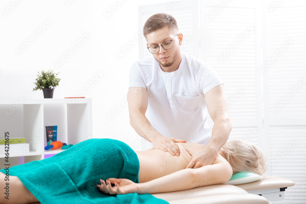 Fototapeta premium Doctor osteopath use therapy for woman in clinic. Concept physiotherapy massage for rehab sport injury athlete back