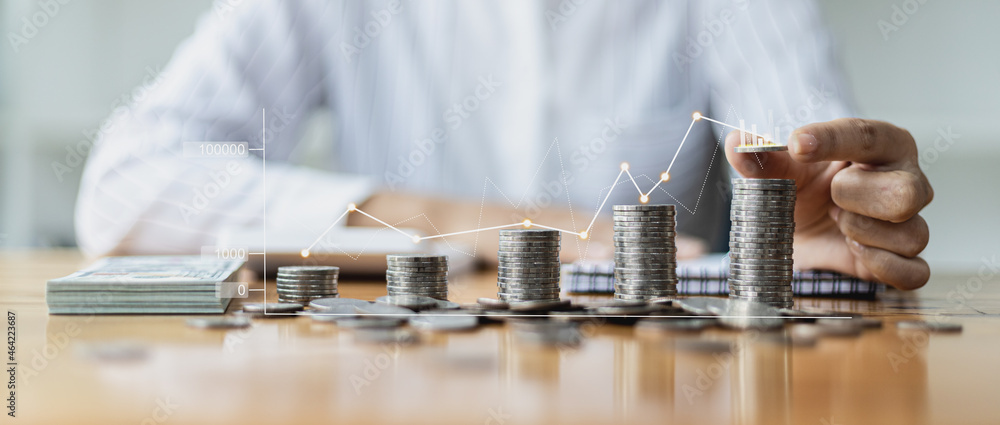 Business Woman putting a coin on a pile of coins. Placing coins in a row from low to high is comparable to saving money to grow more. The concept of growing savings and saving by investing in stock - obrazy, fototapety, plakaty 