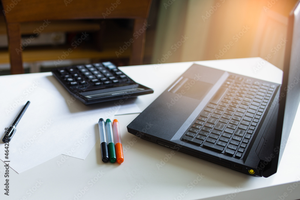 Desk with a laptop and stationery. Home office for online work and training Desk with a laptop and stationery. Home office for online work and training