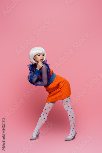 Pretty young asian pop art woman posing on pink background