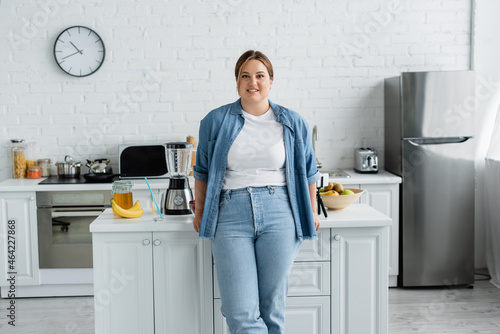 Smiling woman with overweight standing near food in kitchen © LIGHTFIELD STUDIOS