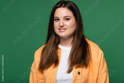 Brunette woman with overweight looking at camera isolated on green