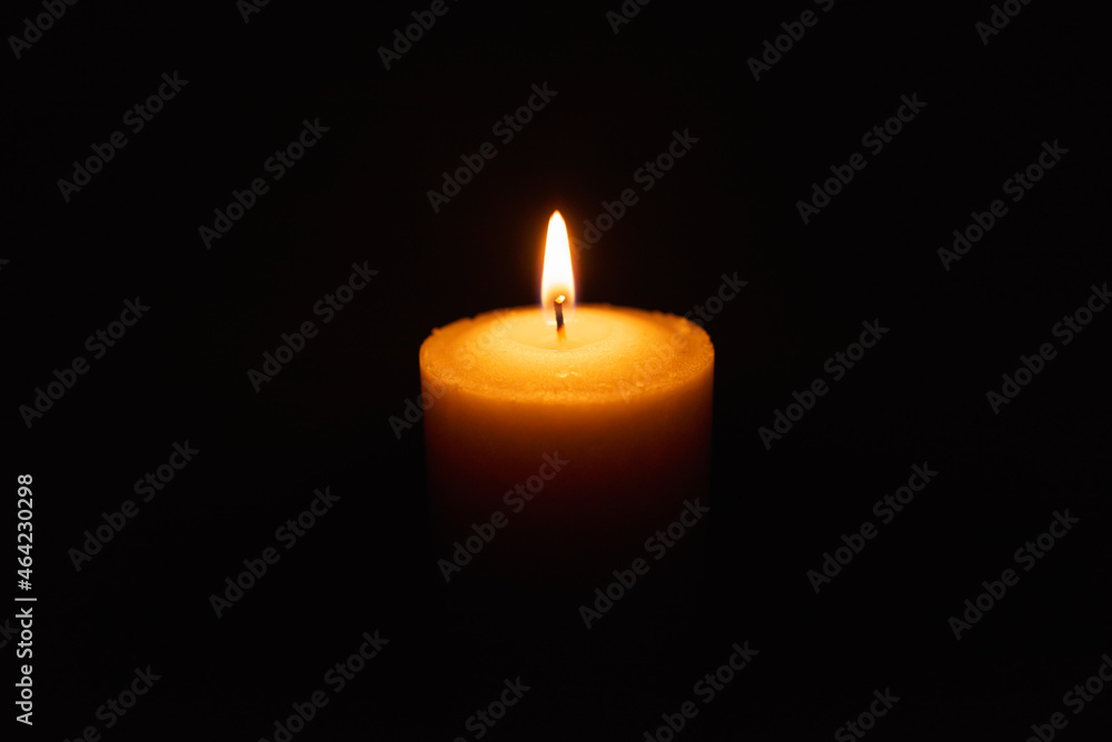 One single light candle burning brightly in the black background.Spiritual candle yellow flame. Flame of candle in the darkness.Copy space. One single light candle burning brightly in the black background.Spiritual candle yellow flame. Flame of candle in the darkness.Copy space.