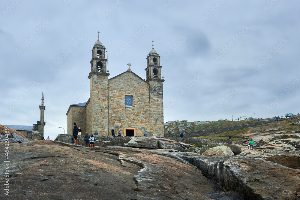 sanctuary of our lady of the boat with visitors seen from the rocks of the coast