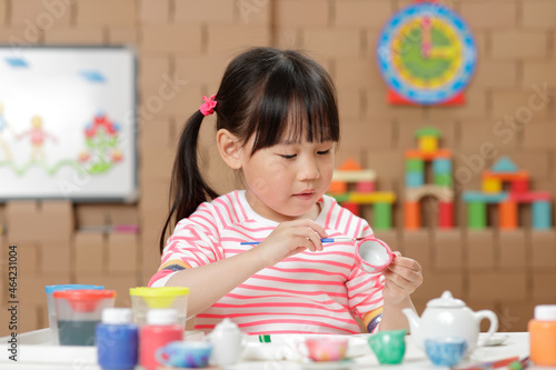 young girl painting tea set craft for homeschooling