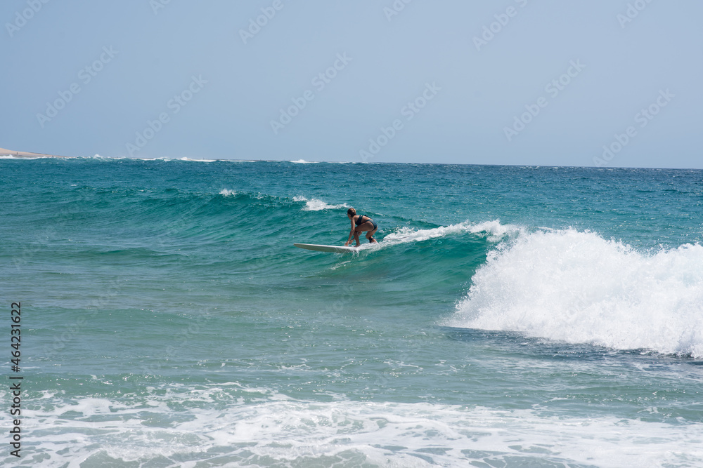 Woman seen riding wave with her surfboard Woman seen riding wave with her surfboard