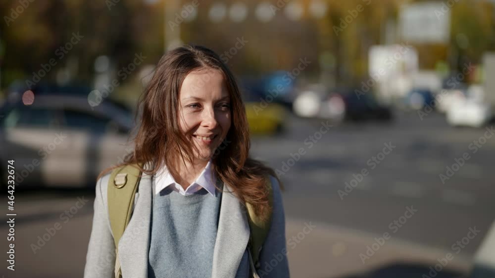 slow-motion front view of a cute adult lady walking down a city street, smiling at the camera slow-motion front view of a cute adult lady walking down a city street, smiling at the camera