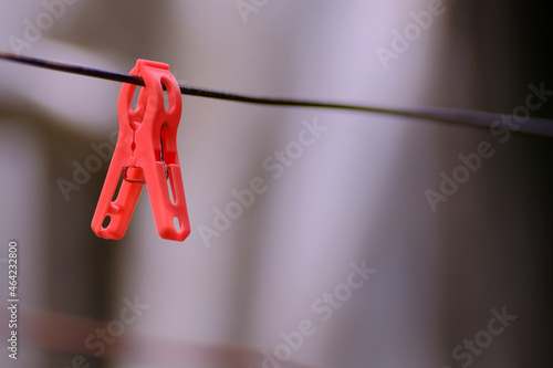 Red clothes pin hanging on the wire
