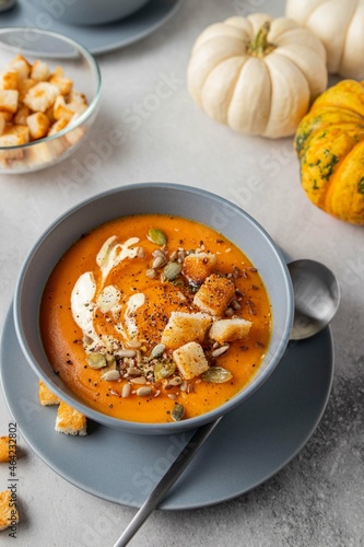Vegetarian autumn pumpkin soup with cream, seeds and toasts. Autumn and winter healthy food concept.