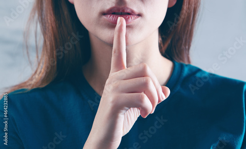 woman showing a sign of silence with her finger photo