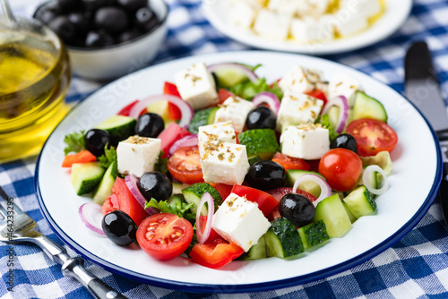 Delicious greek salad with black olives, feta cheese and olive oil on plate
