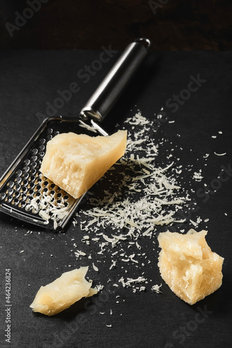 Grated cheese close-up on a dark kitchen table. Chunks of parmegiano cheese on the kitchen table photo