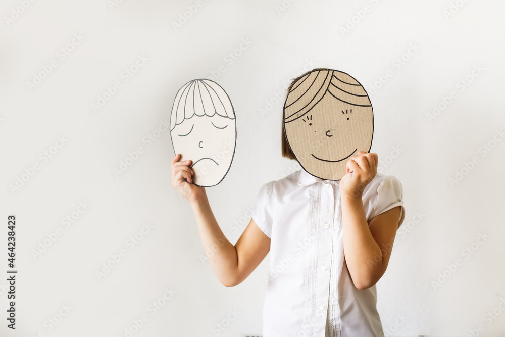 child with masks of emotions, joy and sadness. Psychology and children's emotions concept - obrazy, fototapety, plakaty 