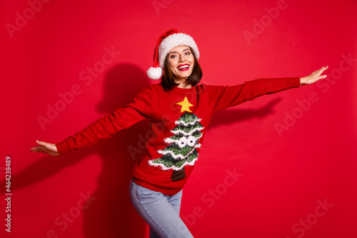 Photo of charming pretty young woman wear ornament sweater dancig enjoying christmas party isolated red color background photo