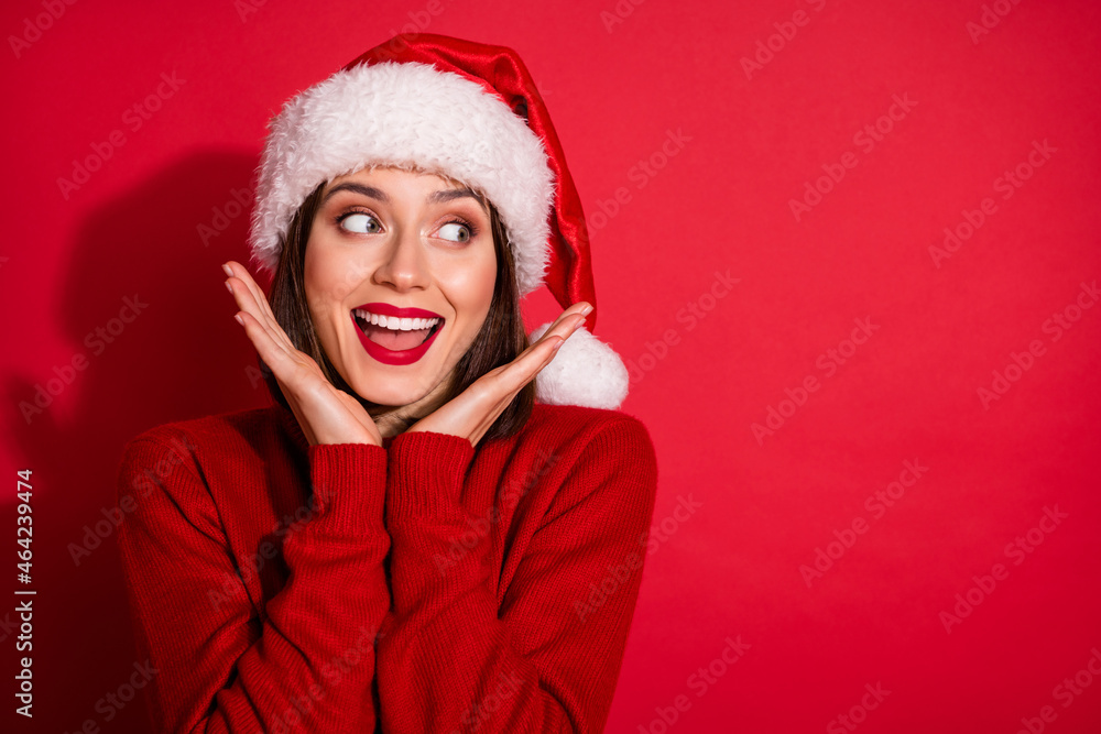 Photo of sweet impressed lady dressed pullover arms cheeks looking empty space celebrating new year isolated red color background Photo of sweet impressed lady dressed pullover arms cheeks looking empty space celebrating new year isolated red color background