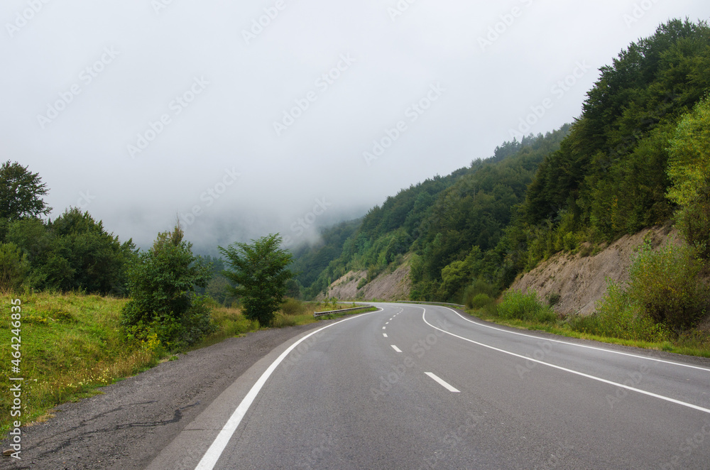 dramatic landscape. morning in the mountains. fog in the background. landscape of early autumn. road to the mountains