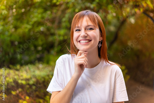 Young pretty redhead woman at outdoors With happy expression