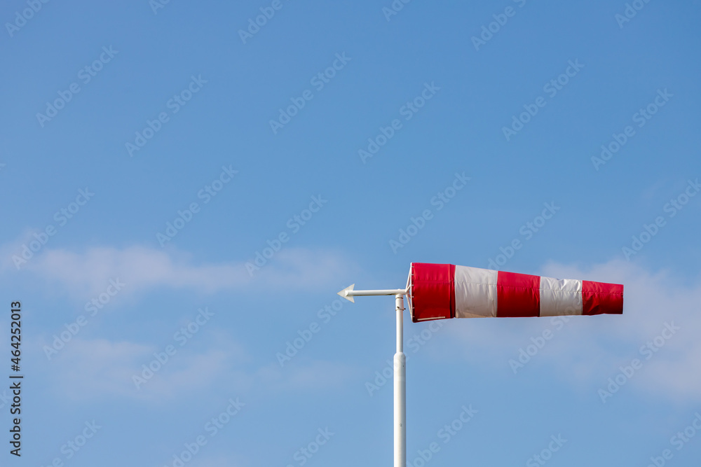 Selective focus of red and white windsock with blue sky background