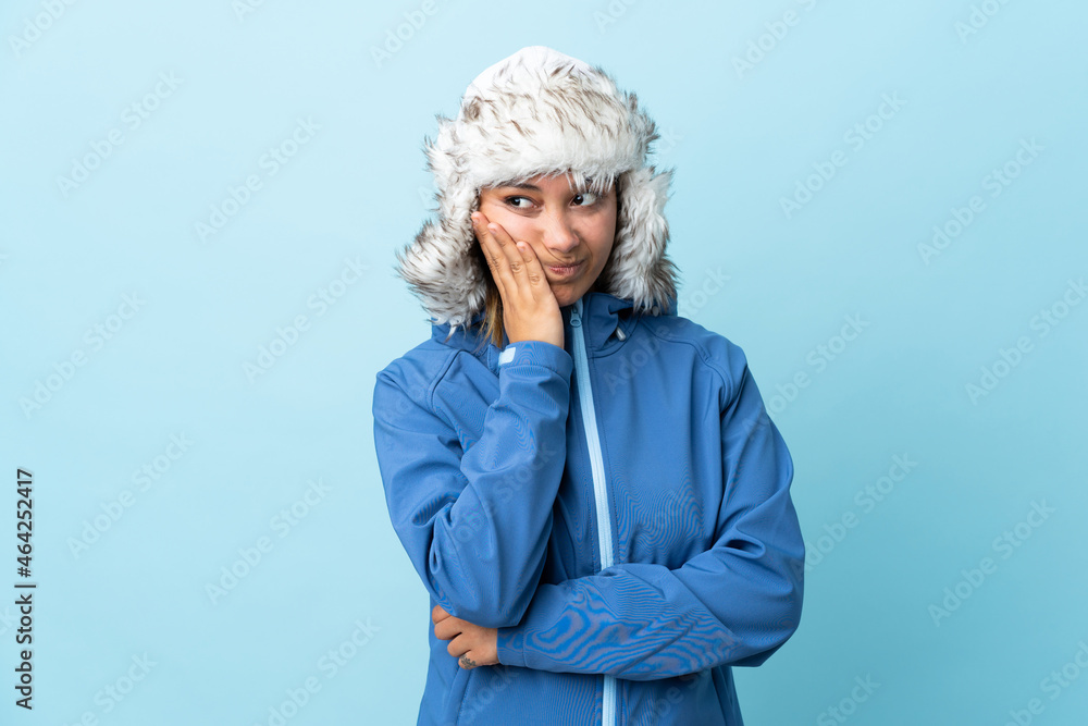 Young Uruguayan girl with winter hat isolated on blue background unhappy and frustrated Young Uruguayan girl with winter hat isolated on blue background unhappy and frustrated