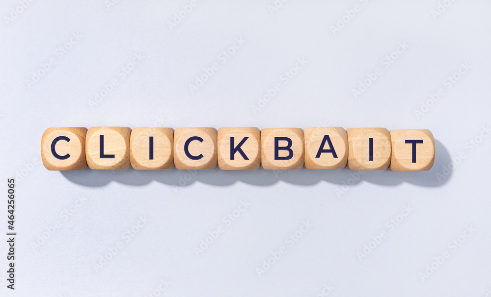 Clickbait word on wooden block isolated on gray background