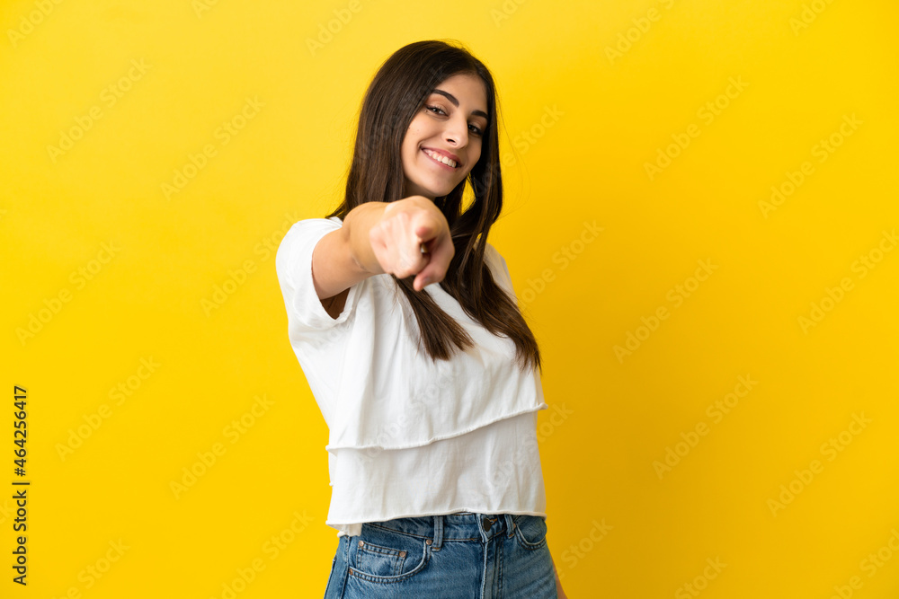 Young caucasian woman isolated on yellow background pointing front with happy expression Young caucasian woman isolated on yellow background pointing front with happy expression