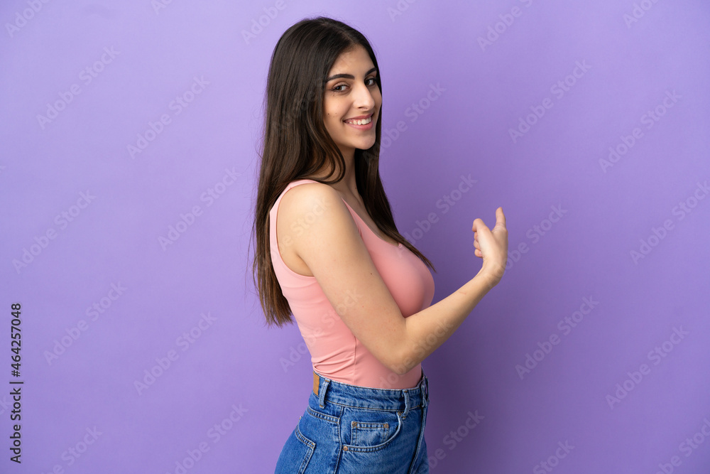 Young caucasian woman isolated on purple background pointing back Young caucasian woman isolated on purple background pointing back