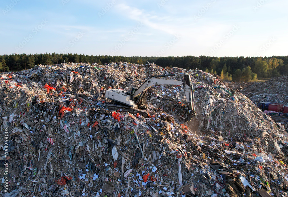 Obraz premium Landfill with Construction and Demolition waste (CDW). Trash disposal for recycling and re-use. Excavator working on industrial landfill. Recycling of building waste materials. Secondary raw.