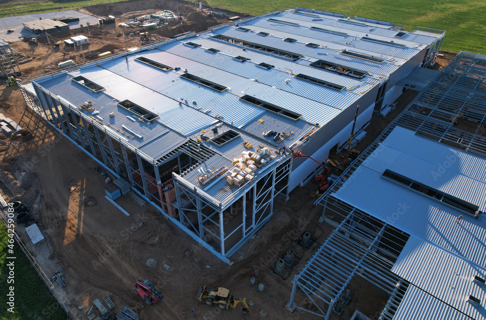 Warehouse Construction from metal structure. Industrial building on light gauge steel framing. Frame of modern hangar or factory. Construction site with steel structure warehouse. Top view on a roof.