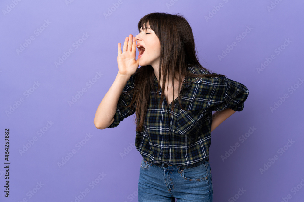 Young Ukrainian woman isolated on purple background shouting with mouth wide open to the side Young Ukrainian woman isolated on purple background shouting with mouth wide open to the side