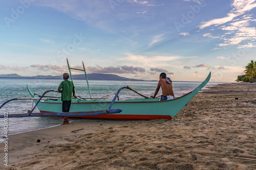 Traditional village fishermen waiting for the tide to change and watching the Taal volcano cloud spread with the wind. No fish, no money, no food., no options. Poverty